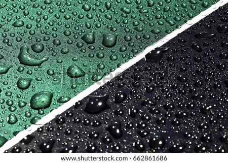 Water drops on a green and black metallic surface