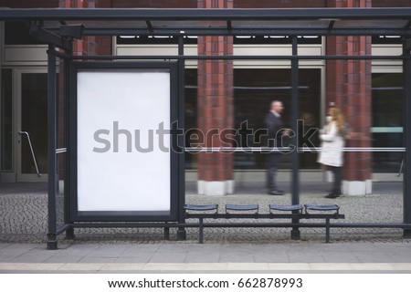 Bus station billboard with blank copy space screen for your advertising text message or promotional content, empty mock up Lightbox for information, stop shelter clear poster in urban city scene Royalty-Free Stock Photo #662878993