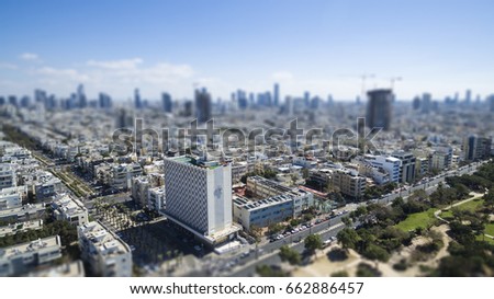 Aerial view of tel aviv skyline with urban skyscrapers at sunset, with cloudy sky, Israel. tilt shift Bokeh effect for a miniature landscape
