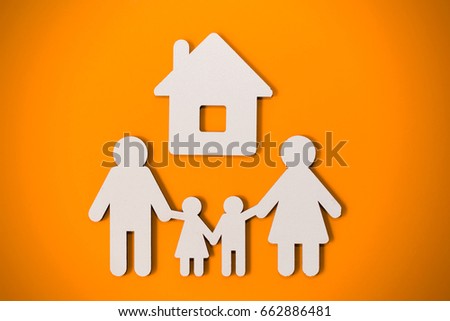 White papercut family silhouette under home on a orange background - loan concept