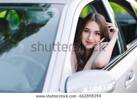 A young girl is driving a car.