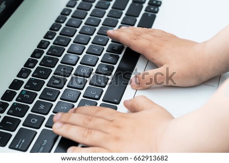 Small boy placed his hands on the notebook keyboard