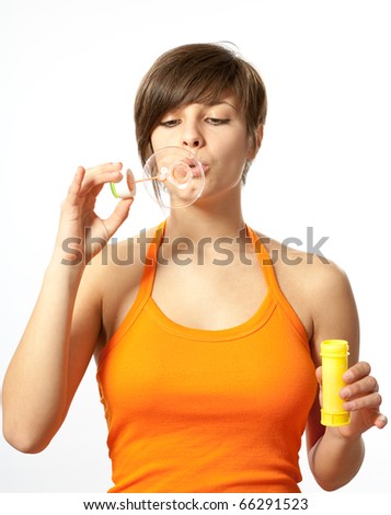 Portrait of a young female blowing soap bubbles