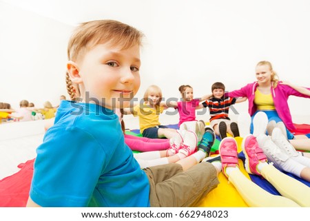 Cute boy playing circle games with friends in gym