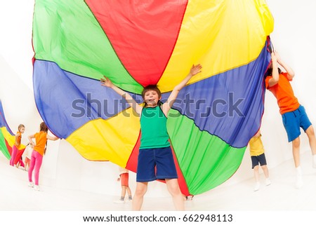 Kid boy standing under tent made of parachute