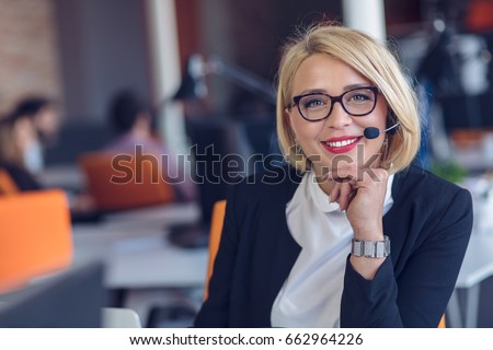 Customer service representative at work. Beautiful young woman in headset working at the computer Royalty-Free Stock Photo #662964226