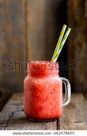 Summer Slushy from Strawberries, Lime and Ice on dark rustic background