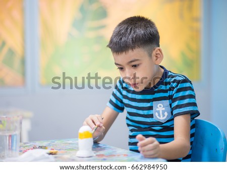 Little boy painting water color in the class
