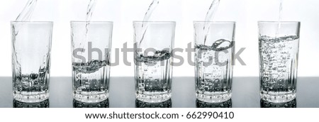 Sequence of a glass being filled with water, white background and on a reflective surface, pouring water