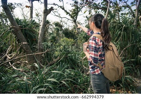 back view photo of beautiful young woman hiker walking on natural park and pointing landscape sharing for friend at summer vacation.