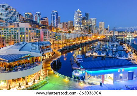 Beautiful view of Seattle waterfront and skyline at blue hour. Marina at pier 66, the great wheel (ferris wheel) can be seen in distance at far left corner. Travel and urban architecture background.