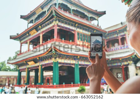 Tourist using mobile phone screen for picture with smartphone of old Lama temple in Beijing, china. Asia tourism travel. People taking photos during vacation.