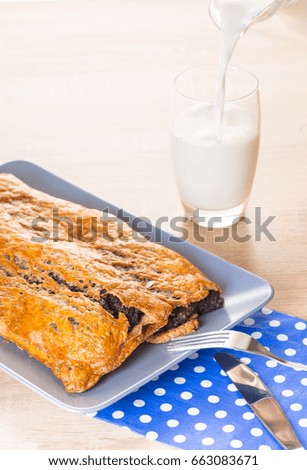 Baking, strudel with poppy seeds and milk on a wooden background