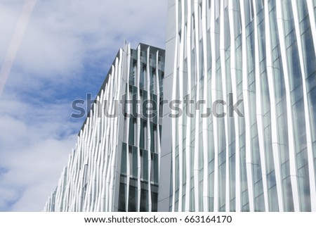 Two office buildings over cloudy blue skies viewed from below