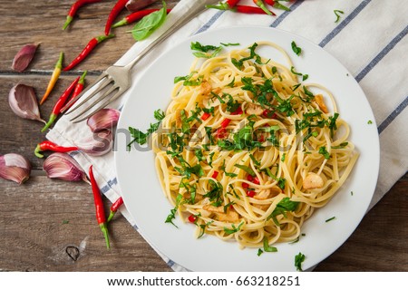 Noodles with garlic and chili on platter with basil decoration Royalty-Free Stock Photo #663218251