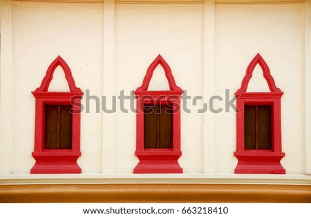 Red window on the church wall in the temple Thai style.