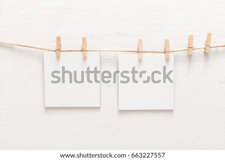 White blank cards on rope, copy space. Creative reminder, small sheets of paper on clothespin, light memo background