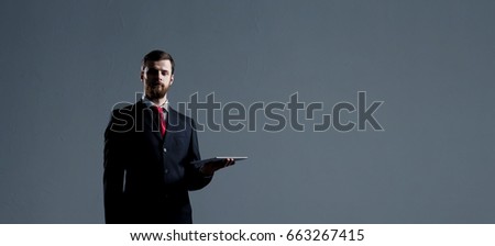 Businessman with a tablet gadget. Black background with copyspace. Business and office technology concept.