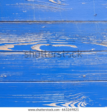 square picture of peeling blue paint texture on hull of old ship in closeup