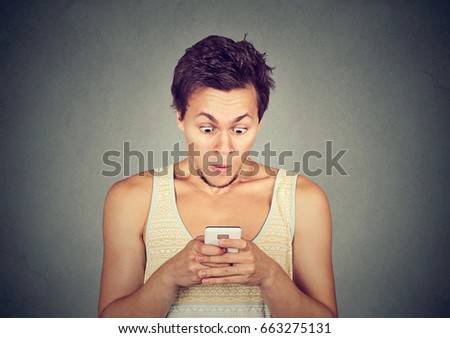 Shocked man reading text message or news on mobile phone 