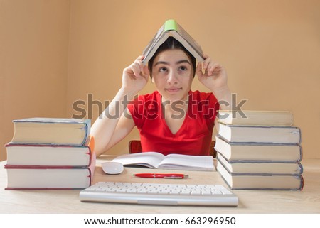 Young Girl student with pile of books and notes studying indoors. Education concept