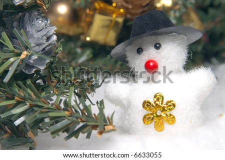 cute snowman to a dark hat in an environment of snowdrifts and christmas evergreen trees