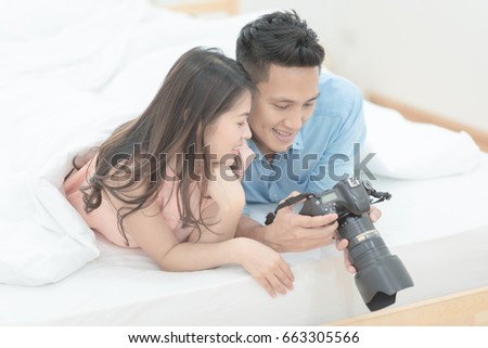 Happy Family,Asian couple lovers enjoy watching photo on DSLR Camera.Photo series of family and happy people concept.