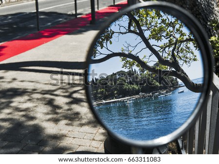 a view on rapallo sea in liguria, trough a mirror reflection of a bicycle.