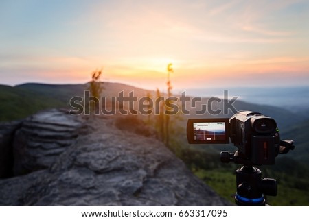 Digital video camera on tripod filming sunrise at mountains. Silesian Beskid, Poland