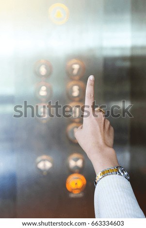 Woman pressing elevator button.