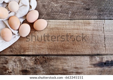 Farm fresh organic brown chicken eggs from free range chickens over a rustic wooden background.