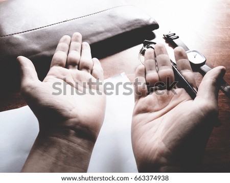 The picture of hands working action on wooden table, consist of laptop, paper, pencil, watch, glasses, soft tone color