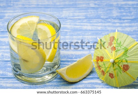 water with a lemon on a wooden background