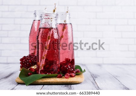 Cold transparent pomegranate drink on a wooden background. Selective focus.