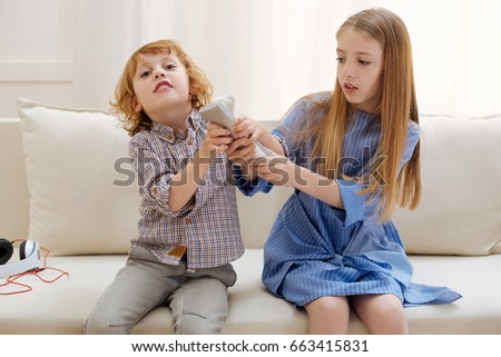 Adorable active children fighting for remote