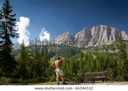 man admiring a breathtaking mountain/alpine scenery (Val di Gardena, Dolomites, Italy)