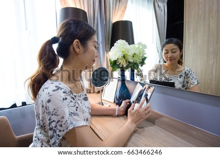 Women are using the tablet in front of the make-up table.