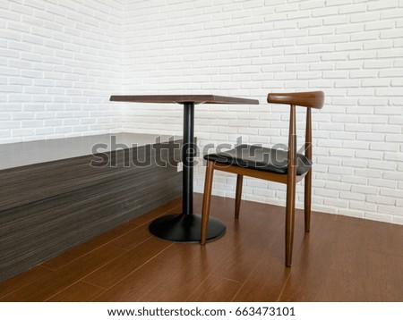 Table and chair in white room with white brick wall 