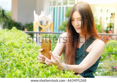 portrait outdoor asia woman playing mobile phone