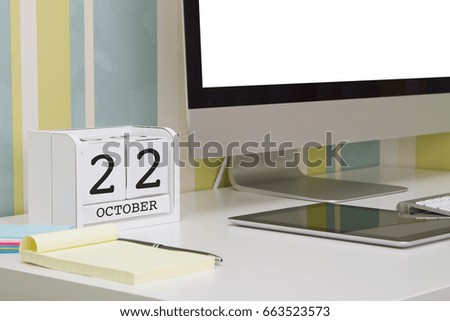 Cube shape calendar for OCTOBER 22 and computer keyboard on table. 