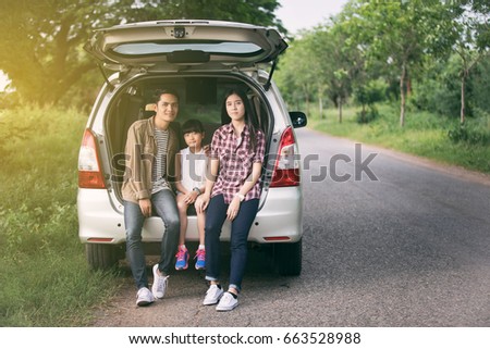 happy little girl  with asian family sitting in the car for enjoying road trip and summer vacation