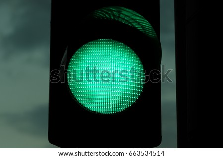 Night close up image of green traffic light with film grain