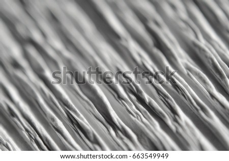 White texture of embossed paper. Macro. Shallow depth of field. Abstract background with deep grooves in the texture of corrugated paper