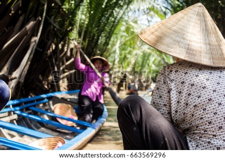 Woman on boat wearing non la or Vietnamese conical hat, Can Tho, Mekong Delta, Vietnam