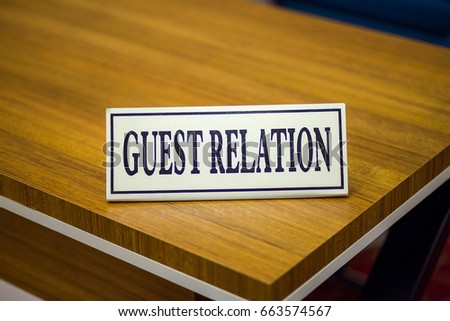 The sign with guest relation inscription is on the table. Guest accommodation in the hotel.  This service for the resolution of all complaints and problems among the hotel guests and tourists.