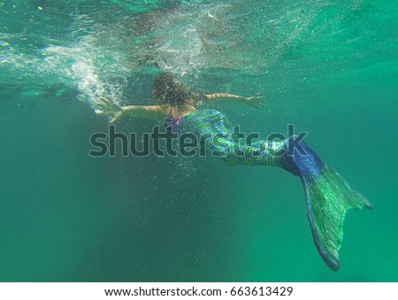 Mermaid in the sea beautiful blond woman with fish mermaid tail swimming underwater in the blue green ocean water, beauty and nature, awesome people, creative picture