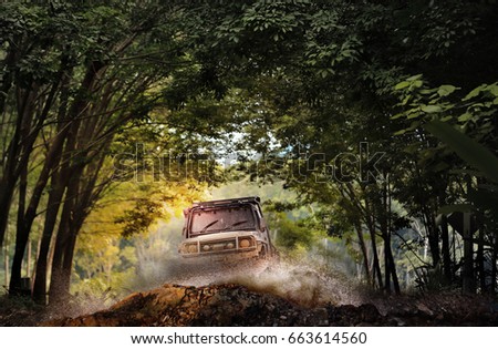 Off road vehicle coming through the trees tunnel.Travel and racing concept for four wheel drive off road vehicle . Royalty-Free Stock Photo #663614560