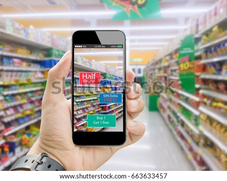 Augmented reality for smart retail business concept.hands holding mobile phone on blurred supermarket as background Royalty-Free Stock Photo #663633457