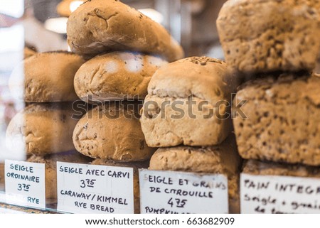 Rye bread display with signs in French at bakery behind window