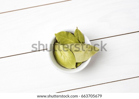 Bay leaves in white bowl. Close up